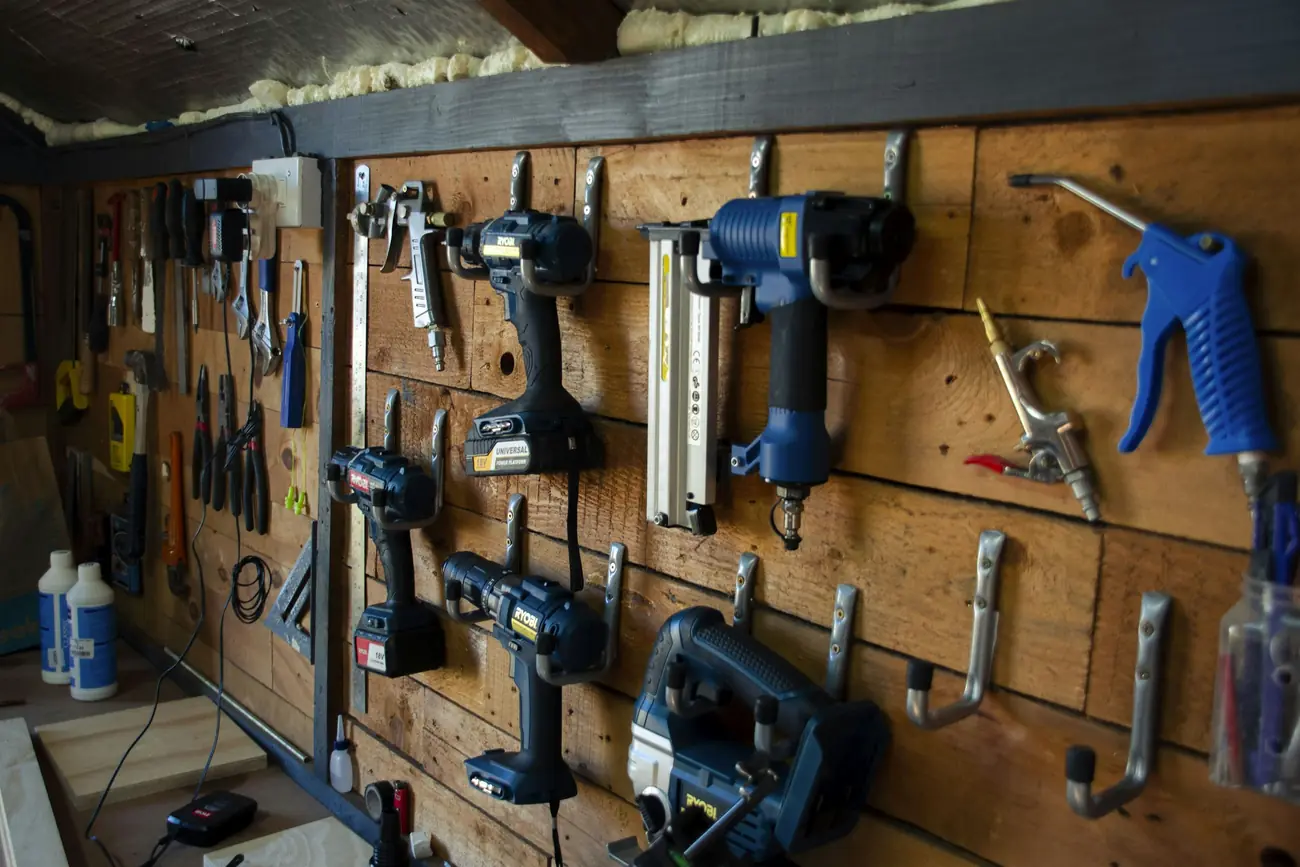 Handwerkzeuge haengen geordnet an einer Werkstattwand
